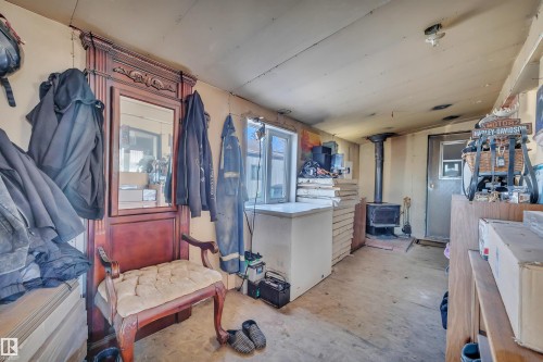 Misc room with a wood stove, concrete floors, and vaulted ceiling - 21 Calmar Mobile Home Park, Calmar, AB - Indoor