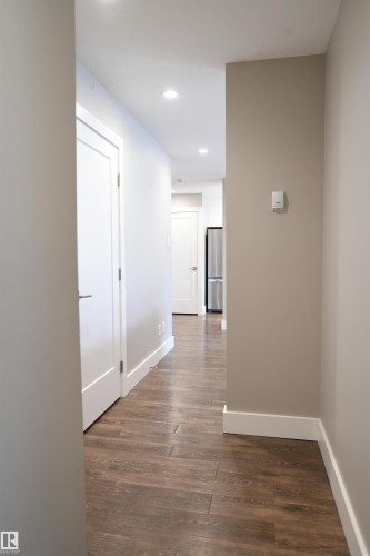 The private bedroom spaces are set away from the open living and entertaining space, and are accessed by this hallway, which also provides easy access to the in suite storage room - 206 8125 110 Street, Edmonton, AB - Indoor Photo Showing Other Room
