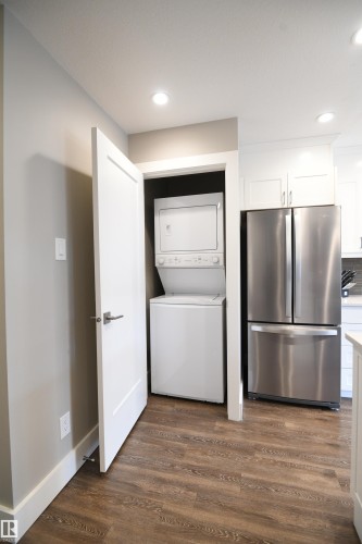 The stacking laundry pair is conveniently located in it's own room, and is set away from the bedrooms, by design.  Details matter, and you will be sure to feel them when you come by for your visit - 206 8125 110 Street, Edmonton, AB - Indoor Photo Showing Laundry Room
