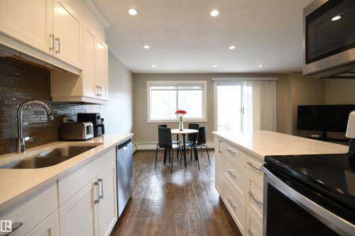 The open layout and sight lines truly make this space live large, tying the kitchen, dining area, and living room together.  The exposure of this second floor unit also gets all day sun, and is on the quiet south side of the building - 206 8125 110 Street, Edmonton, AB - Indoor Photo Showing Kitchen With Double Sink