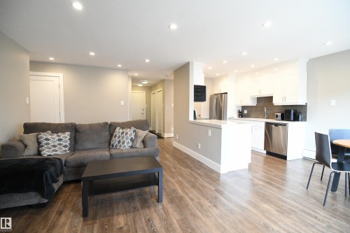 Warm toned vinyl plank flooring throughout really ties the space together.  Loads of LED pot lights were added during the extensive renovation, adding warmth, character, and ambience - 206 8125 110 Street, Edmonton, AB - Indoor Photo Showing Other Room