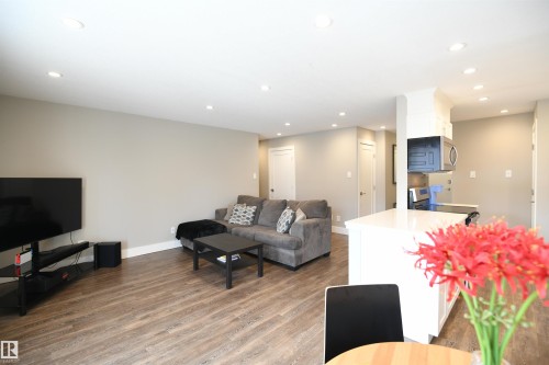 Thanks to the generous floor space, furniture options abound.  Choose a large sectional or minimalist modern pieces.  There is versatile room for whatever your design appetite is and neutral tones flow throughout - 206 8125 110 Street, Edmonton, AB - Indoor Photo Showing Living Room