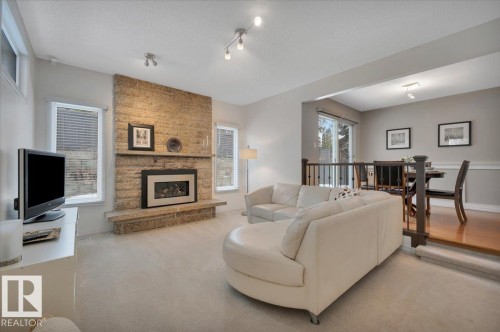 featuring a gas fireplace - 705 Riddell Street, Edmonton, AB - Indoor Photo Showing Living Room With Fireplace