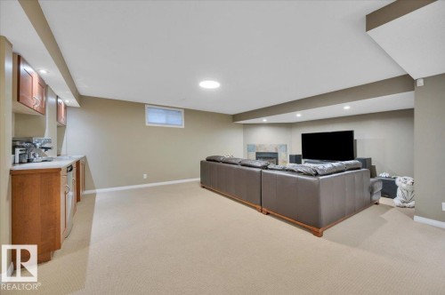 Spacious lower level living area featuring light-colored carpeting, recessed lighting, and a window - 705 Riddell Street, Edmonton, AB - Indoor Photo Showing Basement