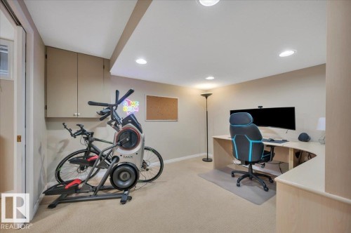Versatile room featuring recessed lighting, a neutral-toned carpet, and built-in cabinetry providing storage - 705 Riddell Street, Edmonton, AB - Indoor Photo Showing Gym Room