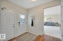 featuring hardwood flooring, a white front door with decorative glass, and the second door leads to the attached double garage. - 705 Riddell Street, Edmonton, AB  - Indoor Photo Showing Other Room 