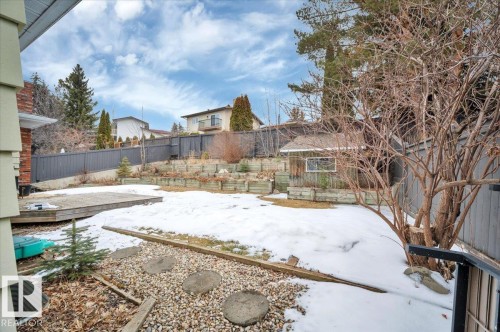 The property features a spacious yard with a deck, a shed, and tiered landscaping - 705 Riddell Street, Edmonton, AB - Outdoor