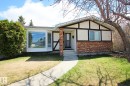 Exterior featuring a large bay window, brick and stucco facade, decorative dark timber accents, a concrete walkway, and established front yard landscaping - 3539 104 Street, Edmonton, AB  - Outdoor 