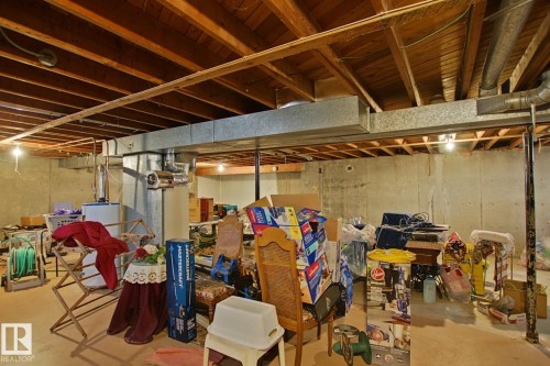 Unfinished basement space featuring exposed wood joists and concrete walls - 3539 104 Street, Edmonton, AB - Indoor Photo Showing Basement