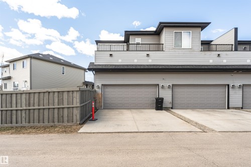 Contemporary multi-level exterior with light gray horizontal siding and a flat black roof - 4452 Annett Common, Edmonton, AB 