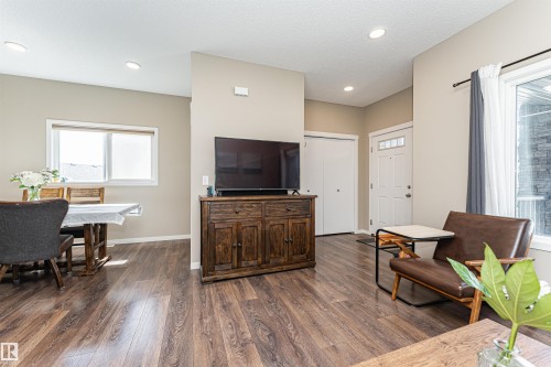 Open-concept living space with wood-finish flooring throughout - 4452 Annett Common, Edmonton, AB 