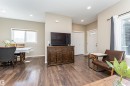 Open-concept living space with wood-finish flooring throughout - 4452 Annett Common, Edmonton, AB 