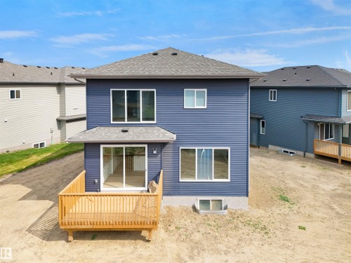Rear elevation featuring a new wooden deck, blue horizontal siding, and a dark shingle roof - 22139 81 Avenue, Edmonton, AB - Outdoor With Exterior