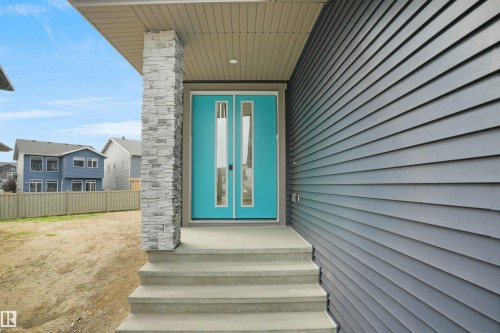 Vibrant turquoise double entry doors with vertical glass inserts - 22139 81 Avenue, Edmonton, AB - Outdoor With Exterior