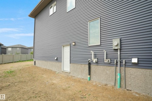 Dark gray horizontal siding exterior with a white door and an exterior light fixture - 22139 81 Avenue, Edmonton, AB - Outdoor