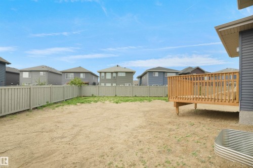 Spacious backyard featuring an elevated wooden deck, gray vinyl siding, and a privacy fence - 22139 81 Avenue, Edmonton, AB - Outdoor
