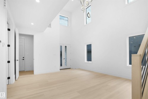 Spacious living area featuring high ceilings, light wood-finish flooring, and multiple windows - 22139 81 Avenue, Edmonton, AB - Indoor Photo Showing Other Room