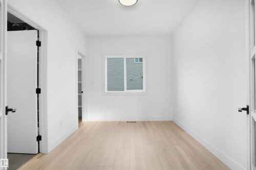 Bright room featuring light wood-finish flooring, white walls, and a contemporary flush-mount ceiling light - 22139 81 Avenue, Edmonton, AB - Indoor Photo Showing Other Room
