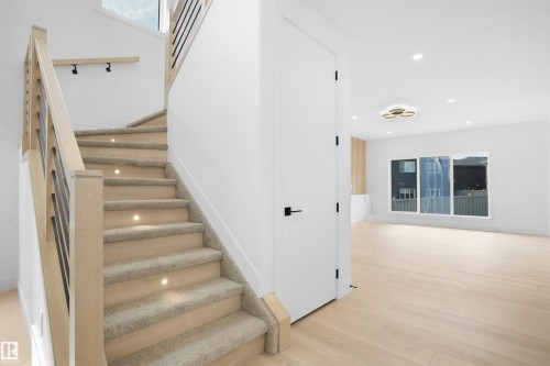 Modern wood and metal staircase featuring carpeted treads with integrated lighting - 22139 81 Avenue, Edmonton, AB - Indoor Photo Showing Other Room