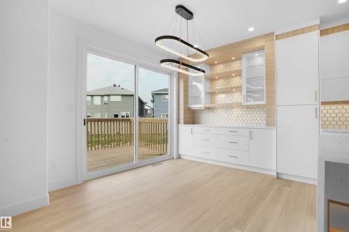 Light wood-finish flooring complements the modern white cabinetry and built-in shelving - 22139 81 Avenue, Edmonton, AB - Indoor