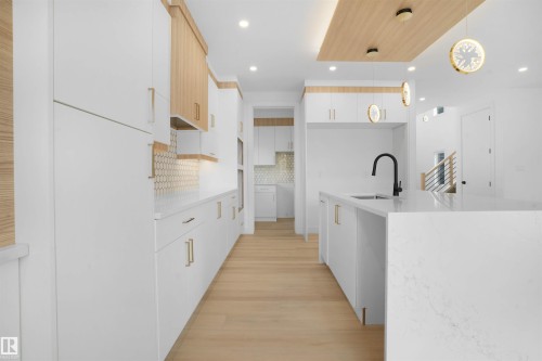 Contemporary kitchen featuring expansive white cabinetry and light wood-finish accents - 22139 81 Avenue, Edmonton, AB - Indoor Photo Showing Kitchen