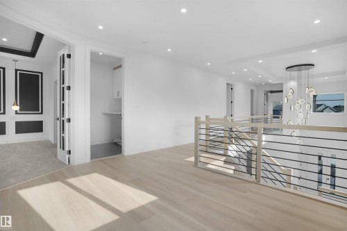 Bright upper-level landing with light wood-finish flooring, recessed lighting, and a contemporary chandelier - 22139 81 Avenue, Edmonton, AB - Indoor Photo Showing Other Room
