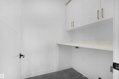 White cabinetry with gold-tone hardware, a white countertop, and dark floor tiles - 22139 81 Avenue, Edmonton, AB - Indoor