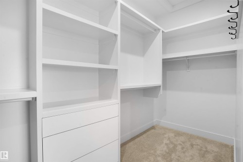 Custom closet system featuring white built-in shelving, integrated drawers, and ample hanging rods - 22139 81 Avenue, Edmonton, AB - Indoor With Storage