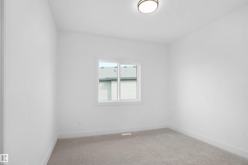 Bright room featuring a single window, neutral carpeting, white walls, white trim, and a flush-mount ceiling light fixture - 22139 81 Avenue, Edmonton, AB - Indoor Photo Showing Other Room