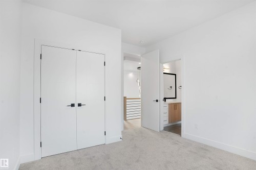 Bright room featuring light gray carpeting, white walls, and a double-door closet with matte black hardware - 22139 81 Avenue, Edmonton, AB - Indoor Photo Showing Other Room