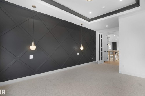 Accent wall featuring dark diamond-patterned wainscoting and two pendant light fixtures - 22139 81 Avenue, Edmonton, AB - Indoor Photo Showing Other Room