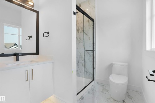 Modern bathroom featuring a glass-enclosed shower with marble-look wall tiles, a white vanity with a light-toned countertop, and matte black fixtures - 22139 81 Avenue, Edmonton, AB - Indoor Photo Showing Bathroom