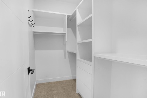 Built-in closet system featuring white shelving, hanging rods, and integrated drawers - 22139 81 Avenue, Edmonton, AB - Indoor With Storage