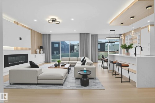 Open-concept living space featuring wood-finish flooring, a linear electric fireplace with hearth, and built-in white cabinetry - 22139 81 Avenue, Edmonton, AB - Indoor Photo Showing Living Room With Fireplace
