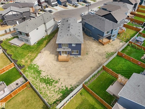 Rear exterior of a two-story residence featuring blue siding, a gray shingle roof, and a ground-level wood deck - 22139 81 Avenue, Edmonton, AB - Outdoor With View