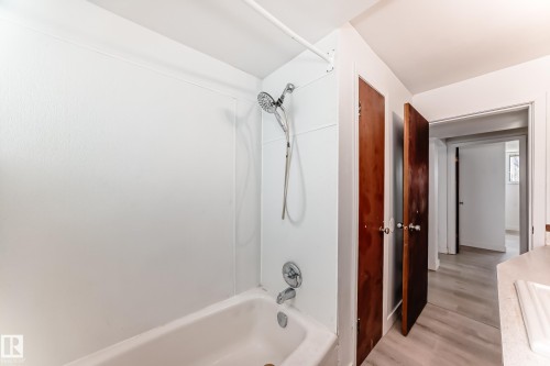 White tub and shower combination with chrome fixtures - 12825 102 Street, Edmonton, AB - Indoor Photo Showing Bathroom