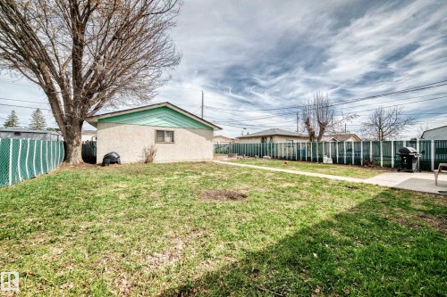 Detached structure featuring stucco siding and a teal gable accent - 12825 102 Street, Edmonton, AB - Outdoor