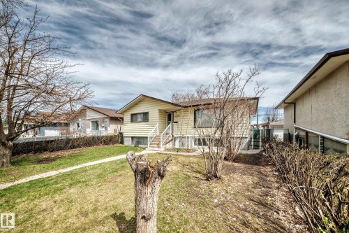 Split-level residence featuring light-colored siding and a brown shingle roof - 12825 102 Street, Edmonton, AB - Outdoor