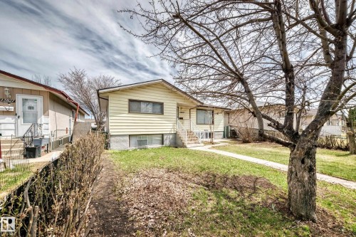 Yellow siding exterior with a white trim around the windows - 12825 102 Street, Edmonton, AB - Outdoor