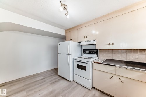 Kitchen featuring light wood-finish flooring, white walls, and track lighting - 12825 102 Street, Edmonton, AB - Indoor Photo Showing Kitchen