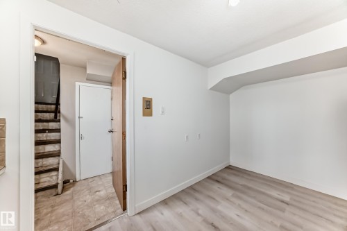 Bright interior space featuring light wood-finish flooring and white painted walls - 12825 102 Street, Edmonton, AB - Indoor Photo Showing Other Room