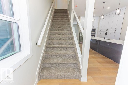 Carpeted staircase with glass railing and white wood handrail - 9814 155 Street, Edmonton, AB - Indoor Photo Showing Other Room