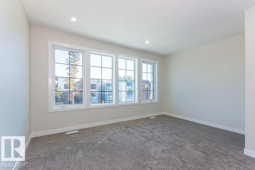 Bright room featuring a wall of three large windows with white trim and muntins - 9814 155 Street, Edmonton, AB - Indoor Photo Showing Other Room
