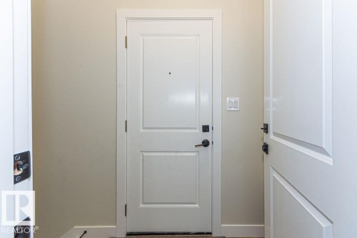 Entryway featuring a white paneled door with matte black hardware, light neutral wall paint, and white trim - 9814 155 Street, Edmonton, AB - Indoor Photo Showing Other Room