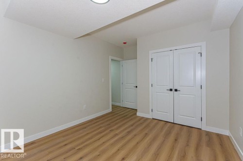 Interior room featuring wood-finish flooring, light neutral wall paint, and white baseboards - 9814 155 Street, Edmonton, AB - Indoor Photo Showing Other Room