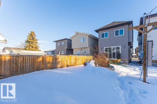 Rear exterior featuring grey horizontal siding, a private balcony, and sliding glass doors - 9814 155 Street, Edmonton, AB - Outdoor