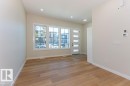Bright entryway featuring wood-finish flooring, a contemporary door with frosted glass inserts, and multiple windows - 9814 155 Street, Edmonton, AB  - Indoor Photo Showing Other Room 