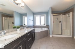 Dual sink vanity with dark wood-finish cabinetry, a light-toned countertop, and chrome fixtures - 