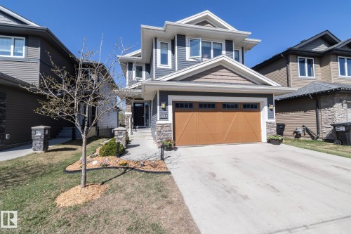 Contemporary two-story residence featuring a two-car garage with a wood-finish door - 2016 Redtail Common, Edmonton, AB - Outdoor With Facade