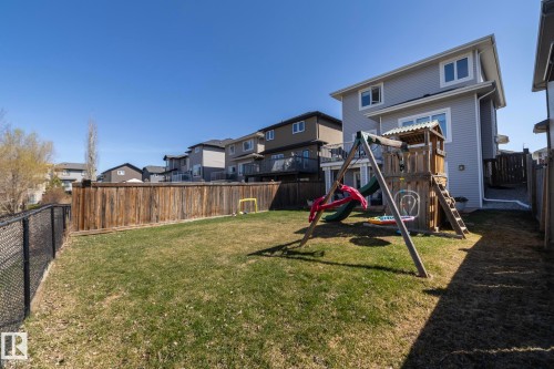 Expansive backyard featuring a lush lawn, privacy fencing, and a chain link fence along one border - 2016 Redtail Common, Edmonton, AB - Outdoor